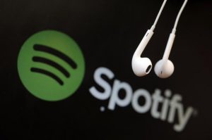 headphones-are-seen-in-front-of-a-logo-of-online-music-streaming-service-spotify-in-this-illustration-picture