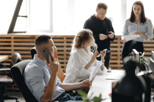 Staff meeting of a young successful team in the light modern office equipped with modern office equipment