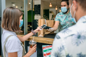 Woman paying with mobile a take away order