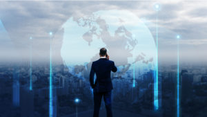 Businessman standing by on a rooftop overlooking the city