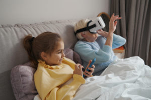 Advanced kid and her grandmother testing virtual reality goggles