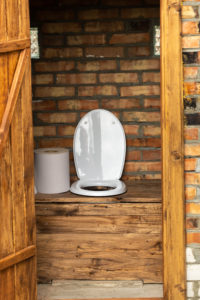 A simple village toilet with a huge roll of toilet paper.Large roll of toilet paper in the toilet