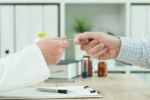 Doctor taking medical insurance card from patient