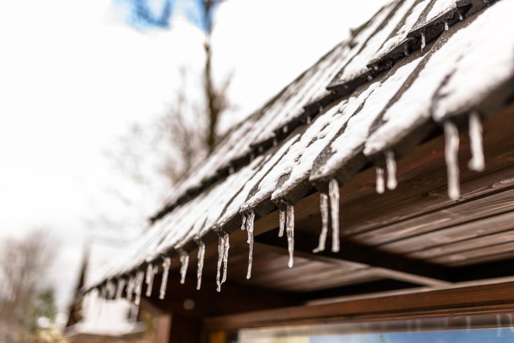 hanging-icicles-from-the-roof-of-a-wooden-building-2022-11-10-18-00-41-utc