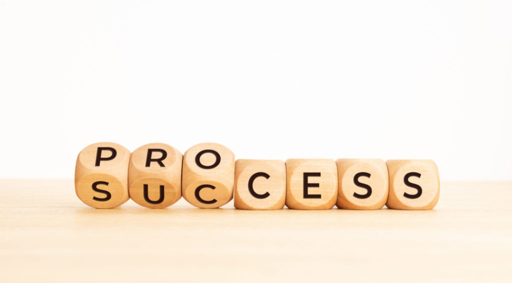 Process success concept. Wooden block flip over word process to success on wooden table. Copy space