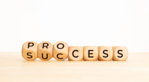 Process success concept. Wooden block flip over word process to success on wooden table. Copy space
