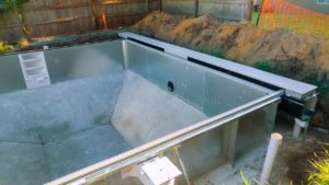 Installation pool in the ground at house backyard. Construction site