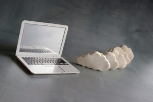 Cloud computing concept. Laptop and white clouds.