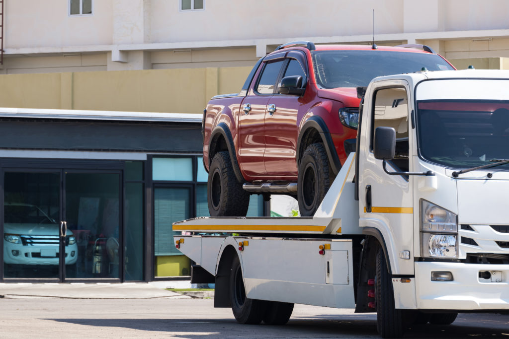 broken-red-pickup-car-loaded-onto-white-towing-tru-2022-09-20-21-36-36-utc