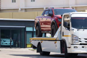 broken-red-pickup-car-loaded-onto-white-towing-tru-2022-09-20-21-36-36-utc