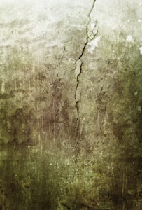 Grunge old concrete wall with cracks in sepia