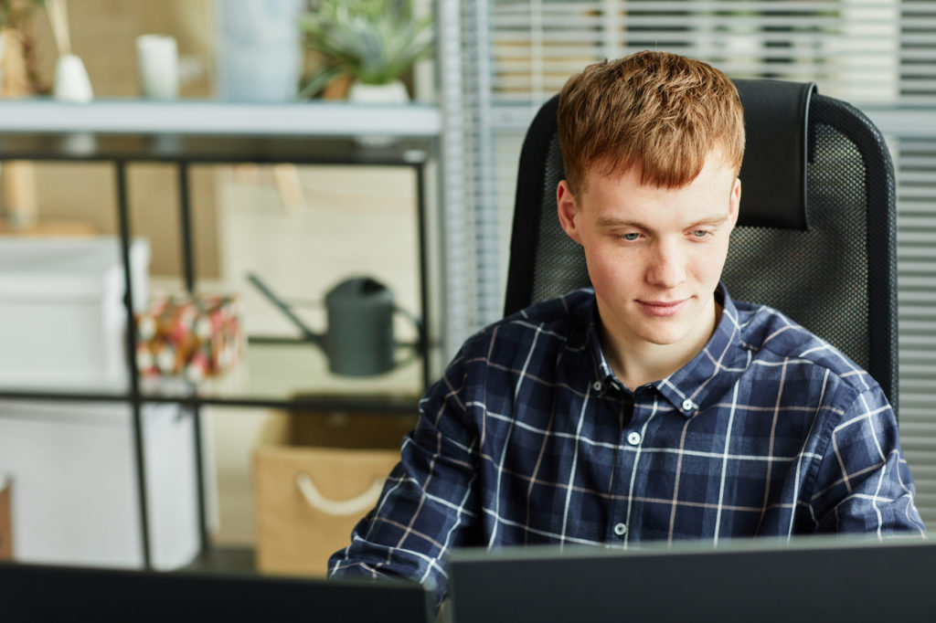 Young IT specialist working at his workplace